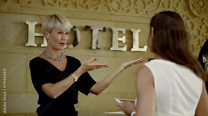 hotel manager is explaining client a rules of the hotel, showing by hands directions of main places