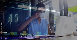 Woman typing on laptop in cafe, sipping coffee while activating encrypted HUD for secure transfer