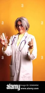 Mature woman doctor holding stethoscope examining senior grandma patient at home. Female physician listens to aged patients heart in a nursing home. Health care concept. Physician auscultating lungs