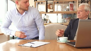 Business partners shake hands at the cafe