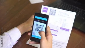 QR Utility Bill. Mobile Bill Payment with QR Codes. A woman scanning the QR code with app and paying. A contactless payment using smartphone