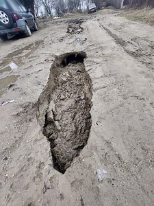 Situație disperată pentru locuitorii din satul Basarabi, județul Dolj. Trei autoturisme și mașina de gunoi au rămas blocate în gropi de un metru