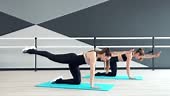 Side motion of two attractive fit women training on mats in ballet...