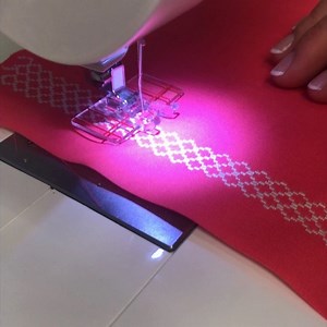 Use a single stitch to create border effects! Attach the Parallel Sewing Foot. Place stabilizer behind the fabric. Select a decorative stitch, and then use the lines on the foot as guides to sew rows evenly side by side. #singersewingmachine #itstartswithastitch #sewingmadeeasy #singersewingcompany #tipsandtricks #isew | Singer Sewing