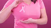 Video of midsection of caucasian woman wearing pink cancer awareness...
