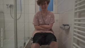 Sick unwell woman holding stomach, suffering from diarrhea, constipation and cystitis in toilet. Abdominal pain during menstruation. Concept of health care and pain. Woman in bathtub with hurt abdomen