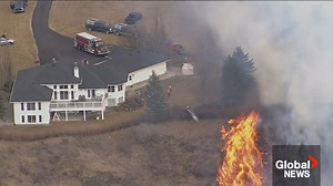 Fire crews are seen battling a massive grassfire northwest of Airdrie, Alta. | Global Calgary | Facebook