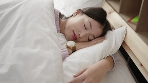 Young chinese woman lying on bed sleeping at bedroom