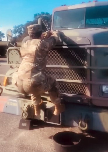 Female Soldier Climbing Military Vehicle
