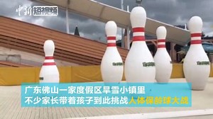 Welcome to the human bowling challenge! Challengers sit on snow tubes, rush along a dry-snow-covered slide to hit as many 5-meter-tall bowling bottles as they can at this resort in Guangdong Province. | China News 中国新闻网