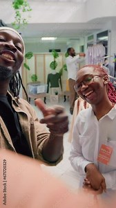 Vertical video Content creator and employee browsing through wares in thrift shop with vintage clothes, presenting hidden gems. Influencer showcasing premium second hand clothing store high street
