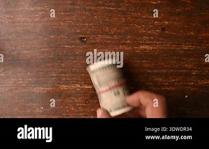 Top View of Man Placing 500 Rupee Notes One by One on Wooden Table
