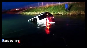 Firefighters and police frantically try to free a woman from a sinking vehicle as water rushes in and sinks them. | American Voices
