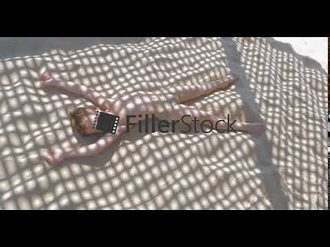 Child making sand angel when relaxing on the beach