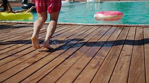 Man jumps in center of donut float in pool - Free Stock Video