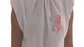 Pink ribbon is pinned on white blouse. Unrecognizable woman turning...
