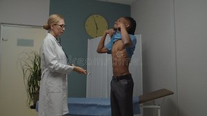 Ärztin, Die Junge Männliche Patientin Untersucht Und Stethoskop in Geschlossenen Räumen Verwendet Stock Video - Video von praktiker, atmung: 235320297