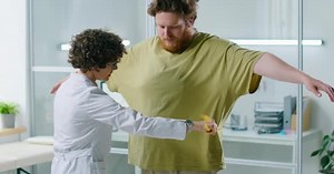Female Doctor Measuring Waist of Overweight Patient