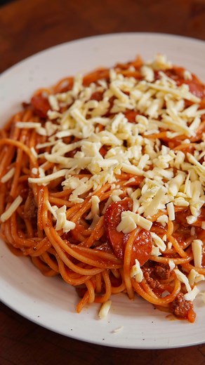 Filipino Spaghetti Ingredients * 1 large brown onion(minced) * 6 cloves garlic(minced) * 3 tbsp olive oil * 1 lbs ground beef/pork * 4 red Filipino hot dogs(sliced) * 3 tbsp tomato paste * 28 oz can crushed tomatoes * 1 cup banana ketchup * 2 tbsp fish sauce * 1/2 cup evaporated milk * 1/4 cup condensed milk * Salt and pepper to taste * Spaghetti Pasta * Magnolia Cheese(substitute with white American cheese) Instructions 1. In a pot, sauté onion and garlic in olive oil on medium heat until trans