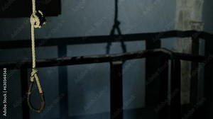 An authentic hanging rope in a real hanging chamber. the rope has a significant shadow on the bare walls, something that enhances the creepy feeling of the place. a 4K video clip.
