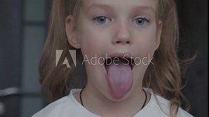 Child girl opens her mouth wide. child shows her teeth and mouth to dentist. mouth is wide open, tongue is stuck out as far as possible, with clear view of tongue and soft palate