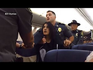 REMOVED FROM FLIGHT: A woman is forcibly removed from a Southwest flight by police