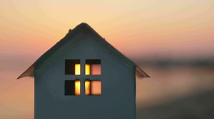 House model on the beach at sunset
