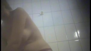 A girl is undressing in the swimming pool changing room