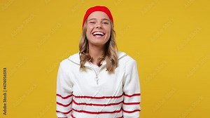 Excited cheerful blithesome young girl teen student wears striped white shirt hat showing thumb up like gesture isolated on plain yellow background studio portrait. People emotions lifestyle concept