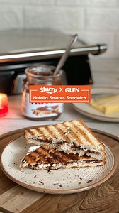 GRILLED NUTELLA SANDWICH WITH Glen India Satisfy your sweet tooth cravings with this delicious #sanwich recipe by Slurrp Community member pakkwaan aka Mamta Choudhary! A delicious blend of warm, melted #Nutella and gooey #marshmallows between two slices of crispy bread. Ingredients: • 2 slices of bread • 2 tbsp Nutella • 5-6 marshmallows • 1 tbsp butter Instructions: 👉 Spread Nutella on bread, add marshmallows and top with another slice. Apply butter, grill till crispy and serve for a sweet, de