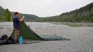 Each campsite on the Stikine River allowed me to rig up a different tarp set up. This campsite was completely flat with not a lot of options for tying the guylines to trees. I had to get creative with the rocks around the river’s flood plain to help anchor the back of the tarp and the front. Who did a better job setting up the tarp? Me or my son Hudson? #jbadventurer #outdoors #survivalskills #alaska #camping #tarpsetup | Jim Baird - Adventurer