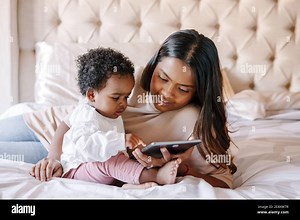 Mixed race Indian black mother with toddler baby girl watching cartoons on tablet. Ethnic diversity. Family mom with kid using technology. Video chat Stock Photo - Alamy