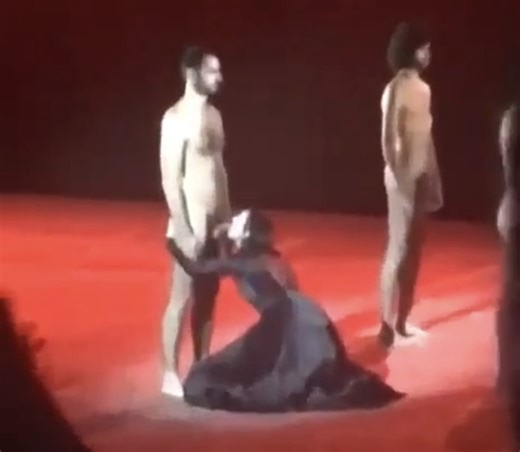 Naked actors show their dicks to a clothed woman