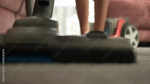 Girl feet by vacuums device. A girl with bare feet walk with vacuum cleaner on the carpet in the room. Generative AI