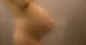 妊娠のコンセプトビデオ。妊婦のお腹の接写。第3トリメスターの間に焦点の外の上品で美しい裸の霧は妊娠体をぼやけた。マタニティフォト蒸気浴。妊婦。