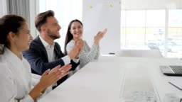 employees applaud in office, managers Smile and clap at table on...