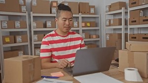 在打包桌前，男人们戴上眼镜和笔记本电脑，周围是栈积如山的包裹和建筑中的货架，专注地提高生产力。 库存影片视频（100% 免版税）3943090157 | Shutterstock