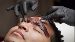 Close-up applying cleansing foam to remove ink after male microblading procedure