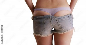 Close view from young woman's rear trying on a pair of torn shorts isolated on white background, Close up of millennial's butt wearing cut off shorts for copy space, 4k