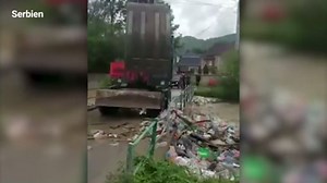 Bagger schaufelt Müll aus Fluss in Fluss zurück