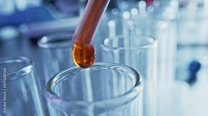 Pharmaceutics Laboratory: Pipette Dropping Red / Orange Liquid into Test Tubes, Medical Research, Analysis. Scientific Lab; Dropper Fills Sample Tubes with Innovative DNA Study Solution.Close-up Macro Stock Video