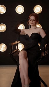 clip-3494415973-elegant-woman-sitting-chair-shiny-black-dress