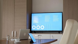 Big TV in business meeting room displaying animated company data and financial charts. Before the meeting. Empty room. Dolly slider 4K footage