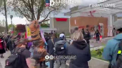 🚨🇺🇸 | INSÓLITO: Un oficial federal aparta un dildo volador antes de que aterrice en su cabeza. Reflejos increíbles exhibidos fuera del Edificio ICE de Portland.