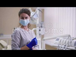 female dentist puts on purple latex gloves