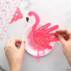 This Handprint Flamingo Craft is a fun handprint craft for kids! Card stock paper, glue and a touch of glitter is all you need to make your own hot pink flamingos! Learn more here>> https://www.madetobeamomma.com/handprint-flamingo/ | Made to be a Momma