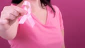 Video of midsection of caucasian woman holding pink cancer awareness...