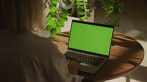 Woman swiping sideways on green screen laptop touchpad