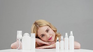 Skin Care, Woman advertises Set of different cosmetic white bottles of cream, serum, spray for skin care routine. Cosmetics packaging. Natural beauty product concept. Mock-up. Advertising, cosmetology