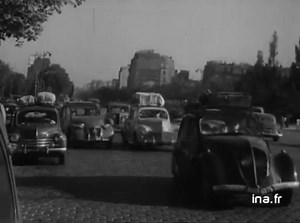 Sujet sur les vacances : les départs, les rues de Paris, vides. LES DEPARTS EN VACANCES ✅ Avenue d'Iéna, déserte avec Arc de Triomphe dans le fond ✅ Sortie de voitures, à une porte de Paris, avec bagages sur la galerie de la voiture ✅ Façade gare de Lyon ✅ Affluence de voitures arrivant dans la cour de la gare ✅ Foule de voyageurs dans le hall des billets ✅ Foule de voyageurs sur le quai ✅ Dans la cour de la gare, voyageur déchargeant ses bagages d'un taxi ✅ Petite fille en culotte, près des val